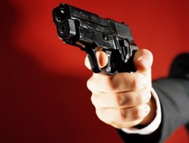 Изображение пистолета направленного на участника сделки под влиянием насилия